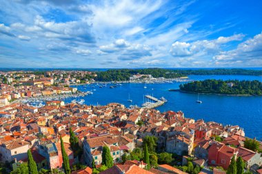 Eski evlerin turuncu çatılarına bakan Aziz Euphemia Kilisesi 'nin Campanile şehrinin ufuk çizgisi, tekne ve yatların bulunduğu pitoresk liman ve Adriyatik Denizi adaları. Rovinj, Istria, Hırvatistan