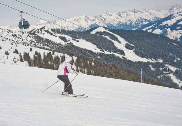Uma mulher está esquiando em uma estância de esqui . — Fotografia de Stock