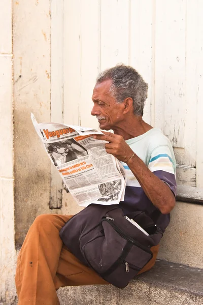 Un hombre leyendo un periódico en la calle. Cuba — Foto de Stock