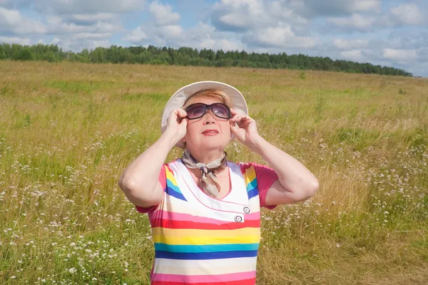 A woman walks along a country road in summer — Stock Photo, Image