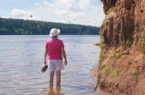 The woman at the steep cliffs with nests of swallows — Stock Photo, Image