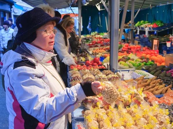 Una mujer elige el producto en el mercado — Foto de Stock