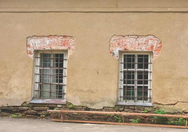 Окна с решетками в старой стене — стоковое фото