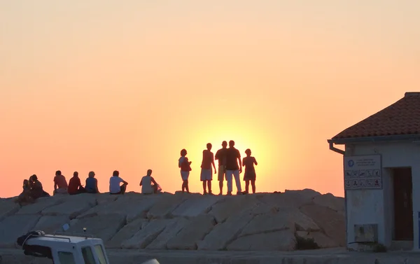 Siluetas de personas sobre un fondo de atardecer — Foto de Stock