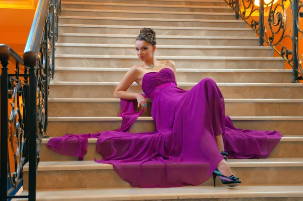 Женщина в длинном платье лежит на лестнице — стоковое фото