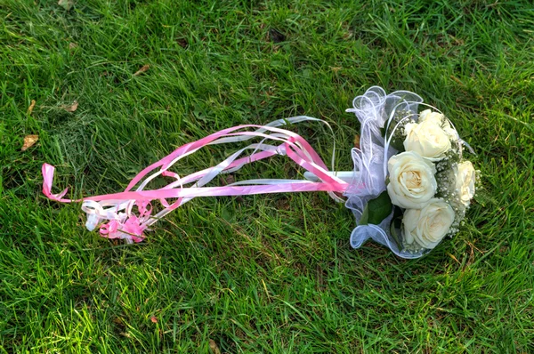 Свадебный букет из роз в траве — стоковое фото