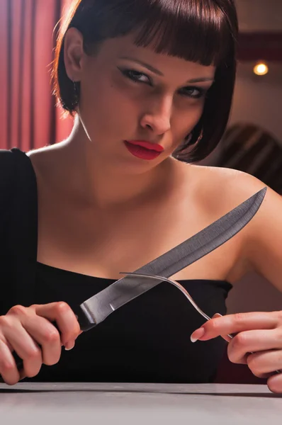 Woman in a black dress with a knife — Stock Photo, Image