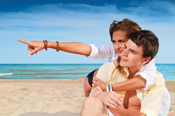 Casal feliz sentado na praia — Fotografia de Stock