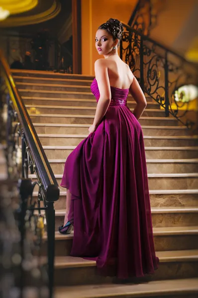 Жінка в довгій сукні лежить на сходах — стокове фото