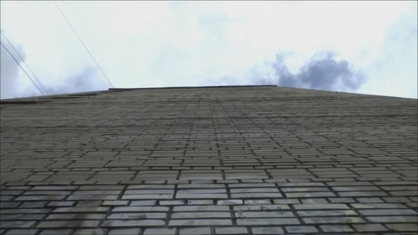 Ziegelsteinmauer ein hohes Haus auf einem Hintergrund aus Wolken — Stockvideo