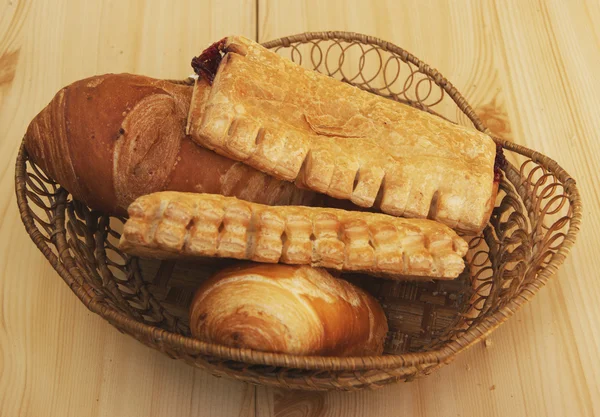 Brood en zoete taarten in mand — Stockfoto