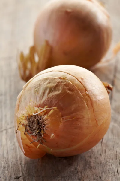 Zwei Zwiebeln auf Holztisch — Stockfoto