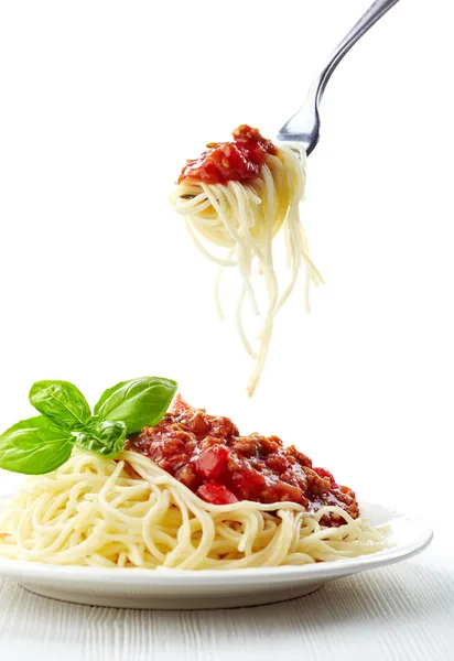 Hoja de albahaca verde y boloñesa de espaguetis sobre plato blanco —  Fotos de Stock