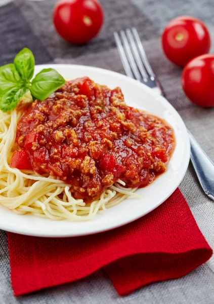 Spagetti bolognese és zöld bazsalikom levél fehér tányérra — Stock Fotó