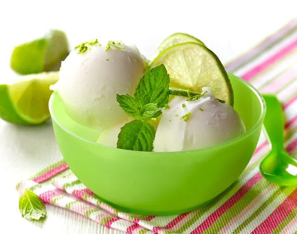 Lemon sorbet decorated with lime slices and mint — Stock Photo, Image