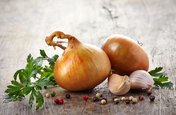 Lök och vitlök på ett träbord — Stockfoto