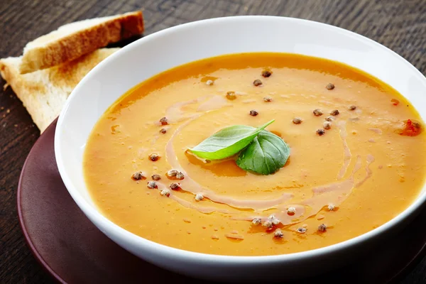Squash soup with basil leaf — Stock Photo, Image