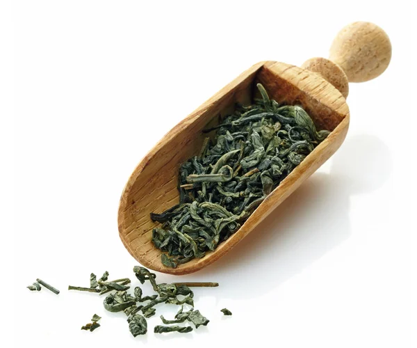 Деревянный совок с сушеным зеленым чаем — стоковое фото