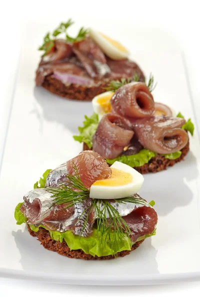Canapes with anchovies and egg — Stock Photo, Image