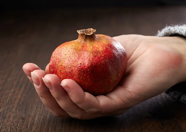 Pomegranate in a hand — Stock Photo, Image