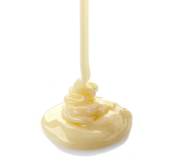 Pouring condensed milk on a white background — Stock Photo, Image
