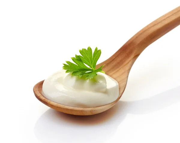 Sour cream in a wooden spoon — Stock Photo, Image