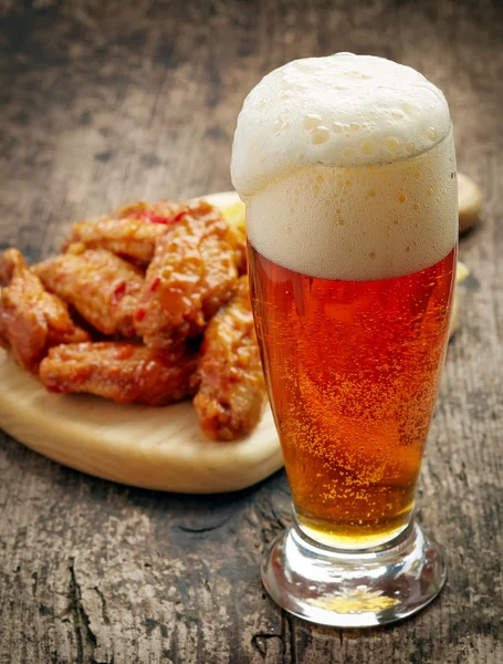 Bicchiere di birra fresca e ali di pollo fritte — Foto Stock