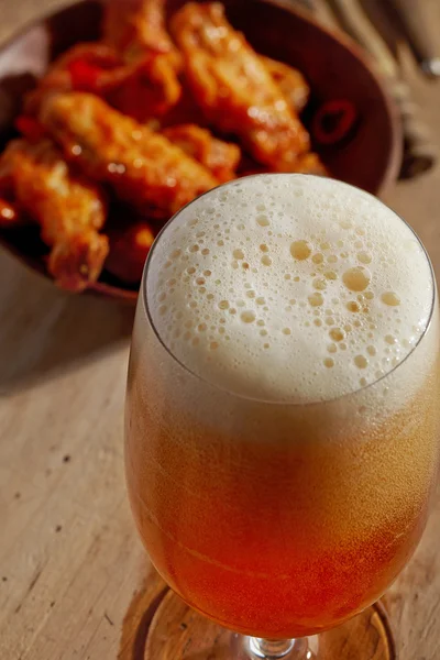 Pohár friss sör és rántott csirkeszárny — Stock Fotó