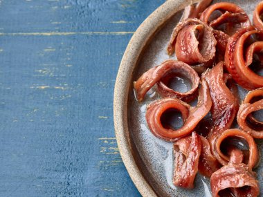 Bir tabak konserve ançüez fileto mavi boyalı ahşap masa, üst manzara