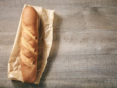 Yeni pişmiş baget ekmeği ahşap mutfak masasında.