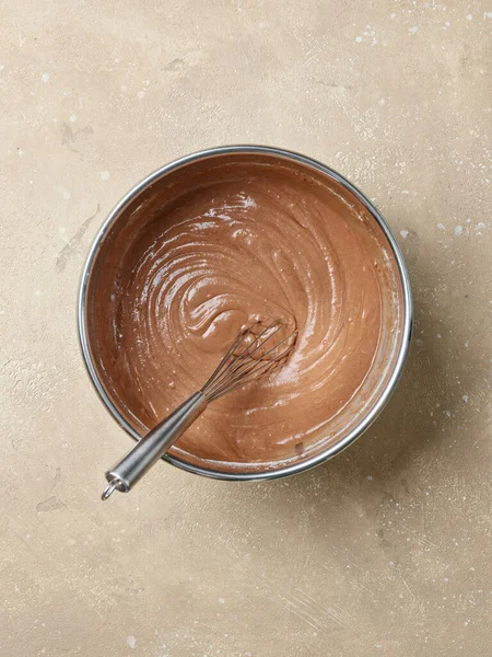 bowl of chocolate cake dough on kitchen table, top view