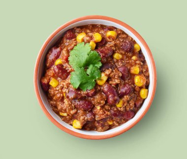 Bir kase Meksika yemeği Chili con Carne yeşil arka planda izole edilmiş, üst manzara