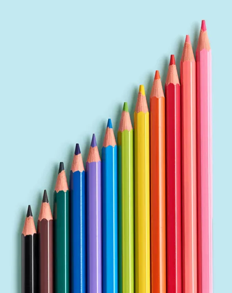 青い背景に描かれた木製の色鉛筆トップビュー — ストック写真