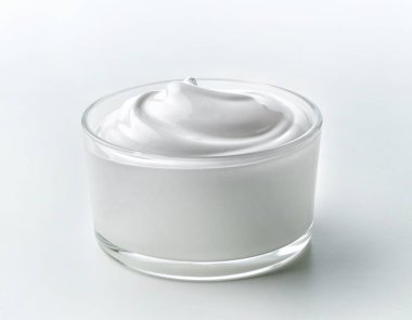 Beyaz mutfak masasında cam kase çırpılmış yumurta beyazı kreması.