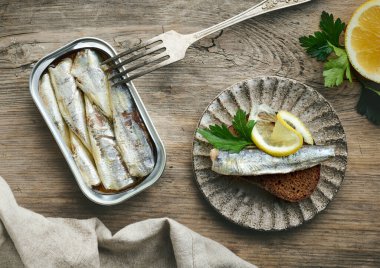 Sardalyalar çatal ve ekmek dilimlerini eski ahşap mutfak masasında açabilir.