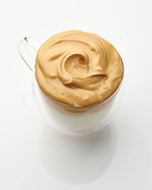 Beyaz masa arkasında bir fincan Dalgona kahvesi.