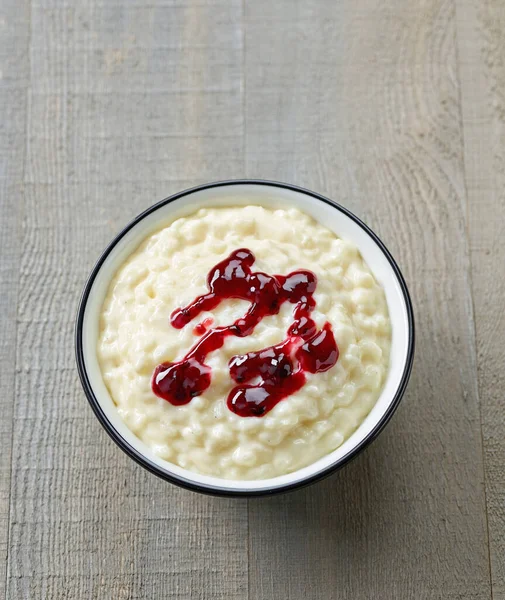 Miska Ryżowego Puddingu Mlecznego Ozdobiona Czerwonym Dżemem Jagodowym Drewnianym Stole — Zdjęcie stockowe