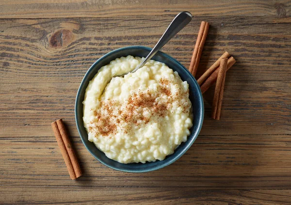 Miska Bezglutenowego Puddingu Ryżowego Cynamonem Drewnianym Stole Kuchennym Widok Góry — Zdjęcie stockowe