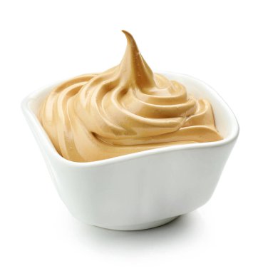 Bir kase kremalı krema ve kremalı krema beyaz arka planda izole edilmiş.