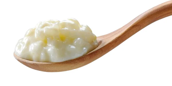 在白色背景上隔离的木制勺子中的无麸质米饭和牛奶布丁 — 图库照片