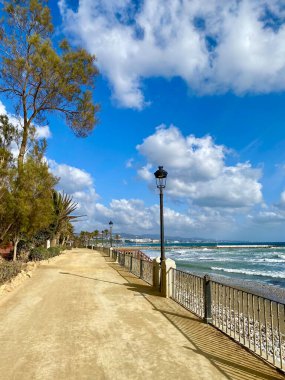 beautiful Marbella promenade landscape with blue sky and white clouds clipart
