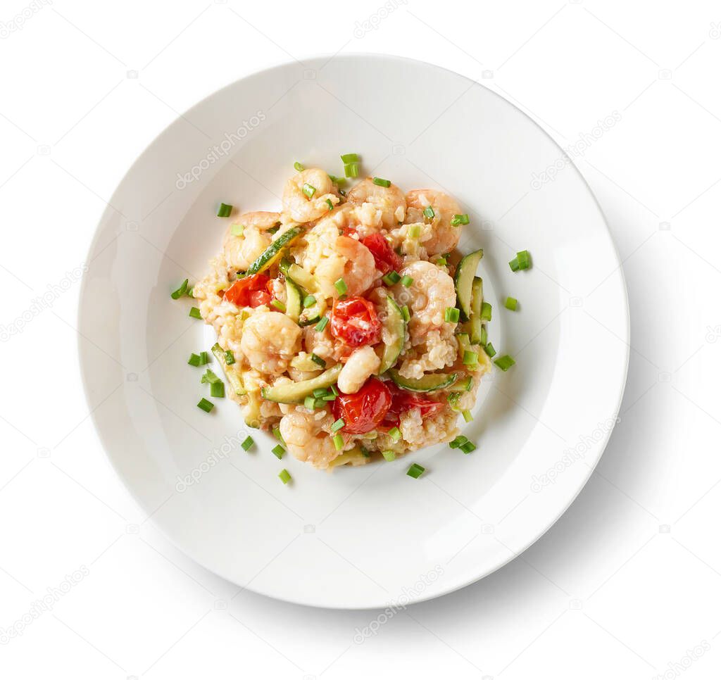 plate of risotto with zucchini and prawns isolated on white background, top view