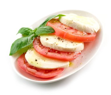 Beyaz arka planda yalıtılmış fesleğen ve zeytinyağlı domates ve mozzarella.
