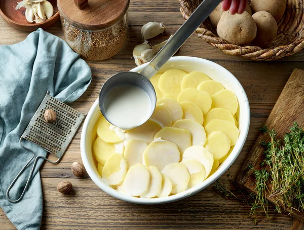 Burgonya Gratin Készítésének Folyamata Tejszín Hozzáadása Szeletelt Nyers Burgonyához — Stock Fotó