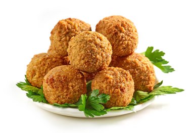 Bir tabak kızarmış falafel köftesi ve beyaz arka planda maydanoz yaprakları.