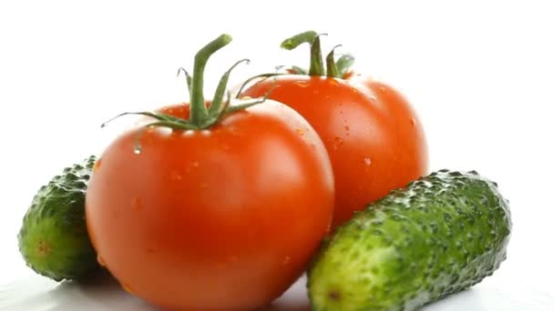 Tomater och gurkor på vitt, roterande — Stockvideo