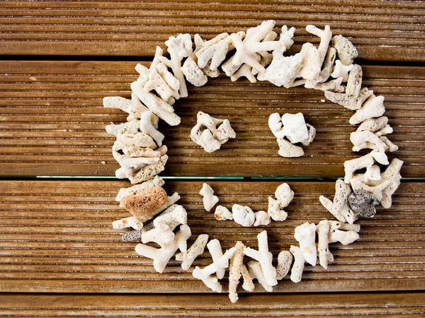 Cara sonriente hecha de guijarros sobre tablón de madera — Foto de Stock