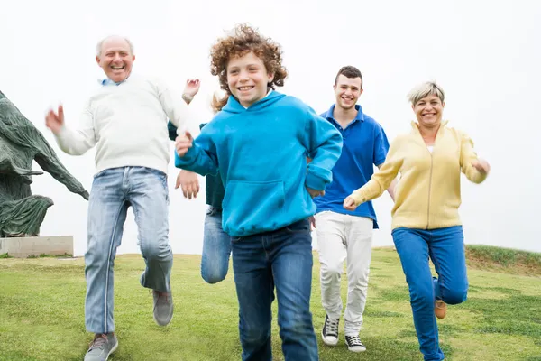 Glückliche Familie läuft auf dem Rasen — Stockfoto