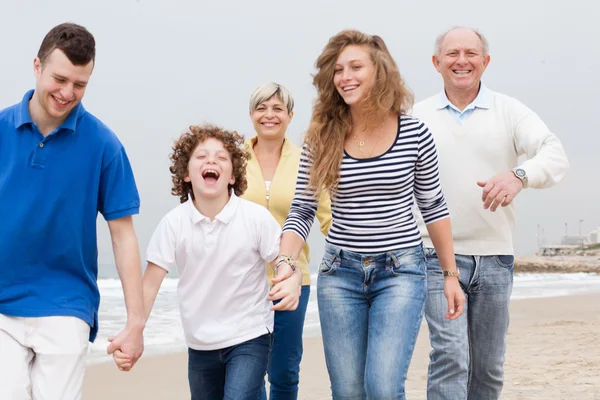 Família feliz andando na praia — Fotografia de Stock