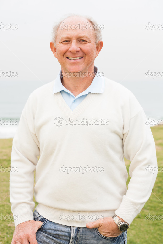 Smiling aged man on grass land background